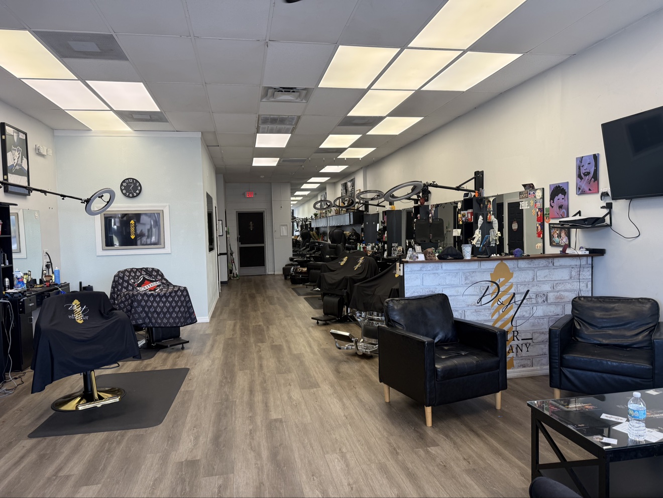 The bright D&H Hair Company shop interior with barber chairs, salon stations, and the front desk