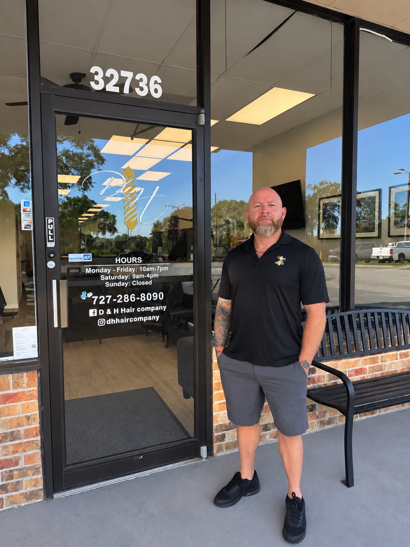 Danny, owner of D&H Hair Company, standing in front of the shop