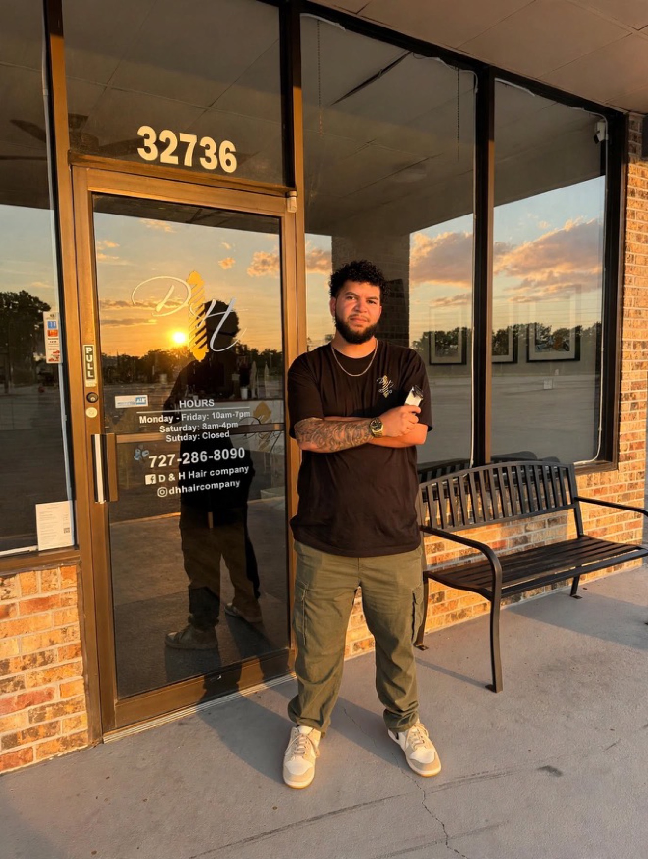 Jacob, barber at D&H Hair Company, standing in front of the shop