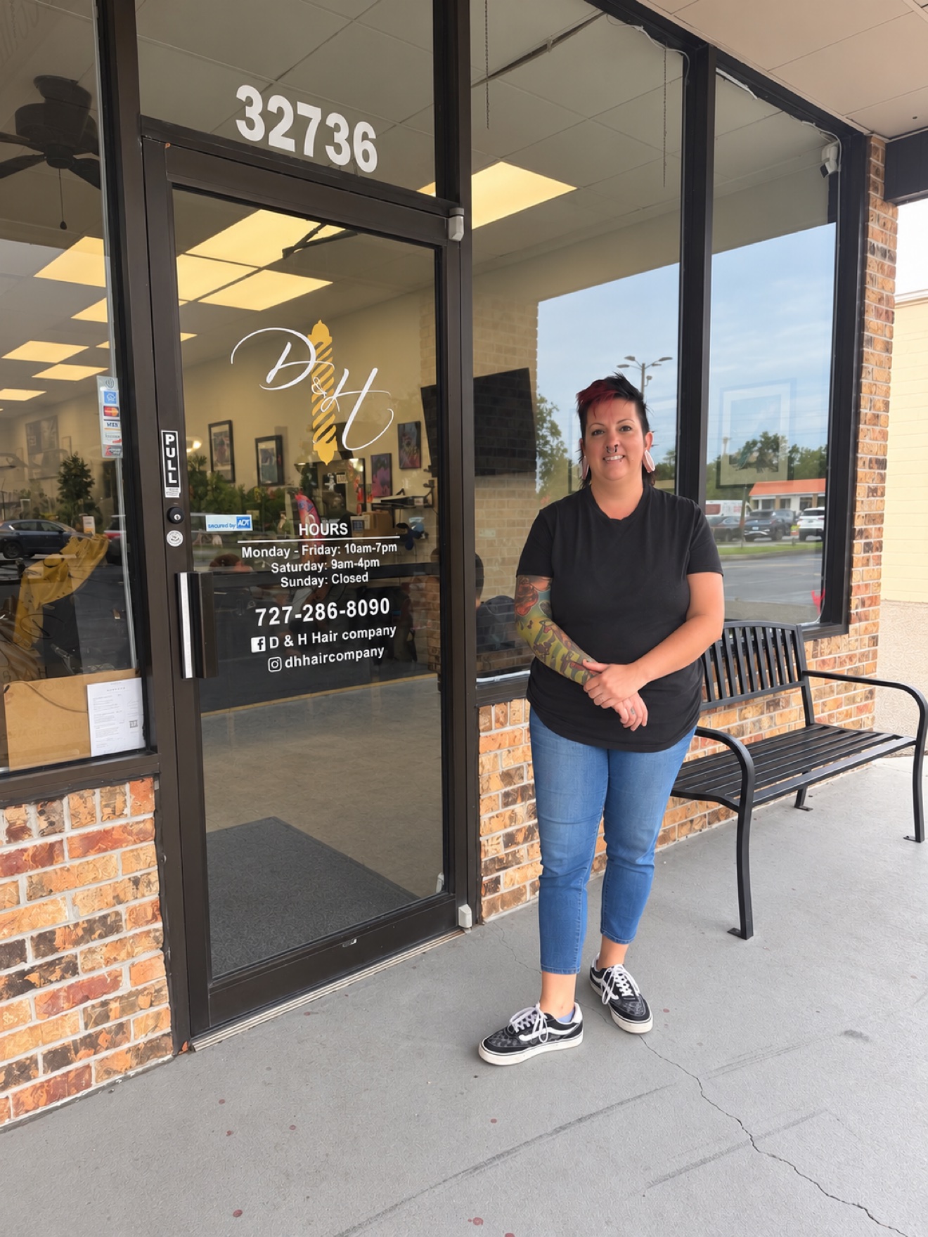 Rae, of the D&H Hair Company team, standing in front of the shop