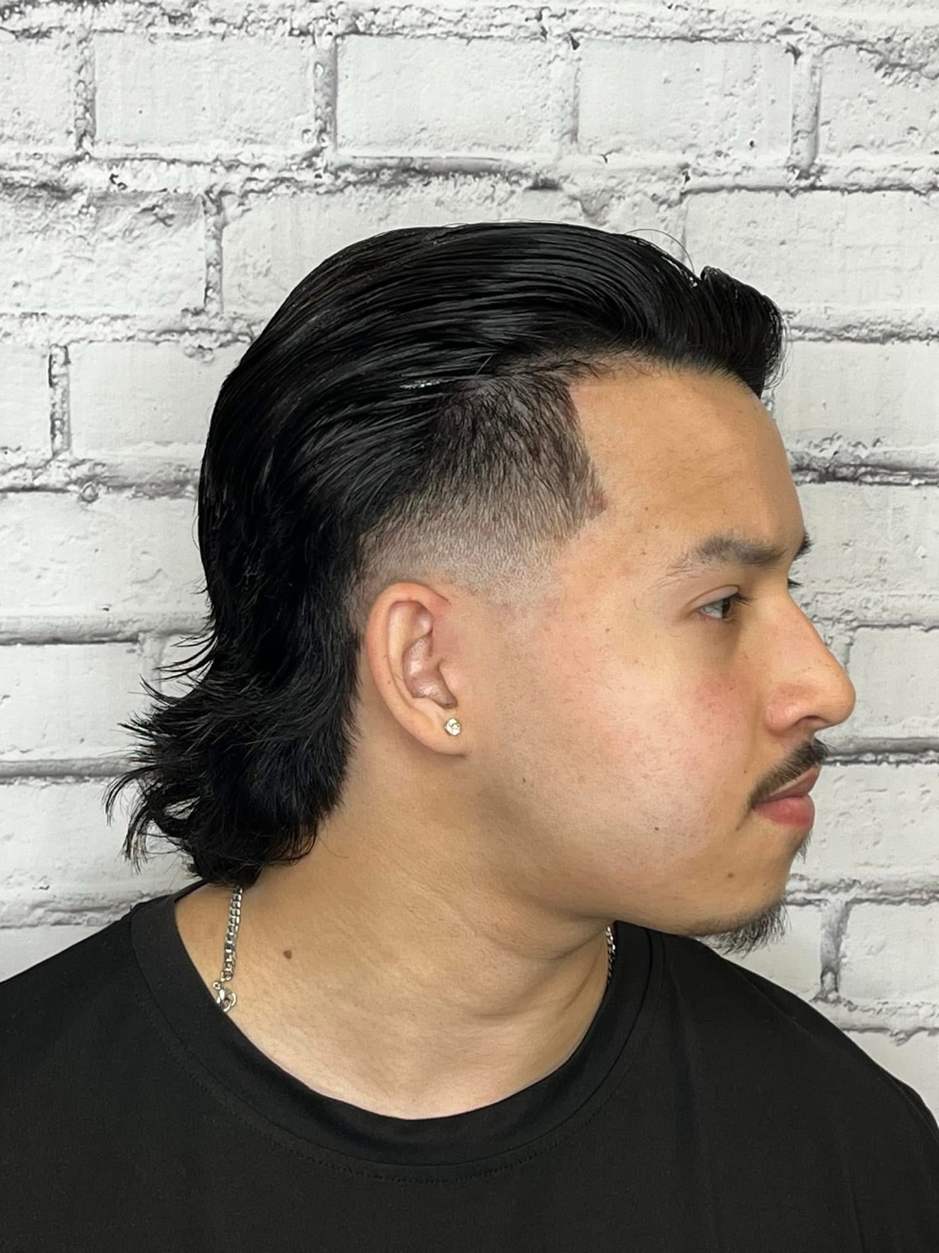 Modern mullet with faded sides and length in back, side view, by Danny at D&H Hair Company