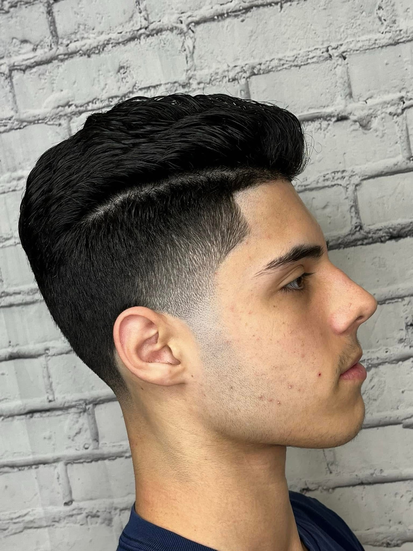 Pompadour with a hard part and skin fade, side view, by Danny at D&H Hair Company