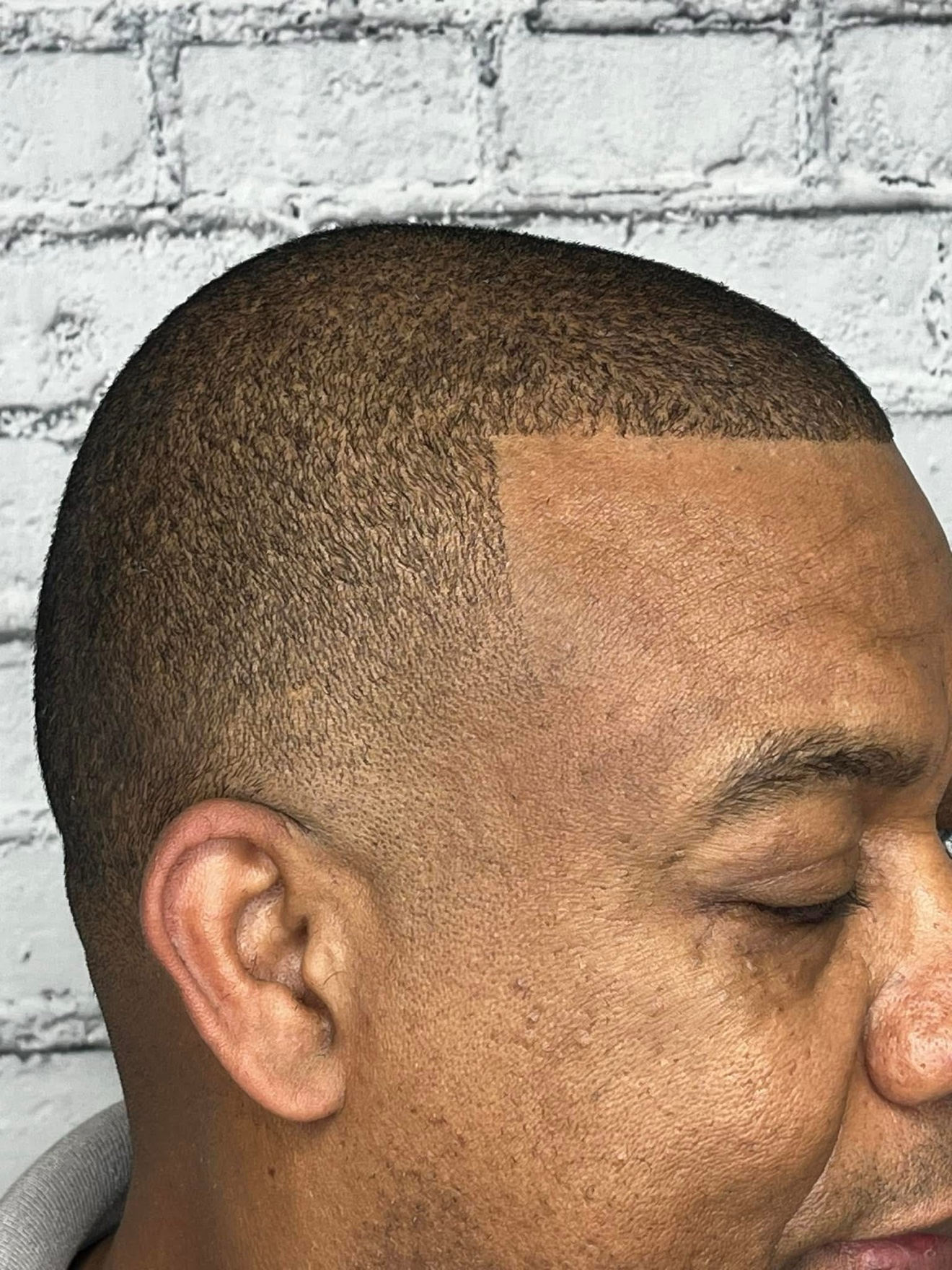 Buzz cut with a sharp lineup, side view, by Danny at D&H Hair Company