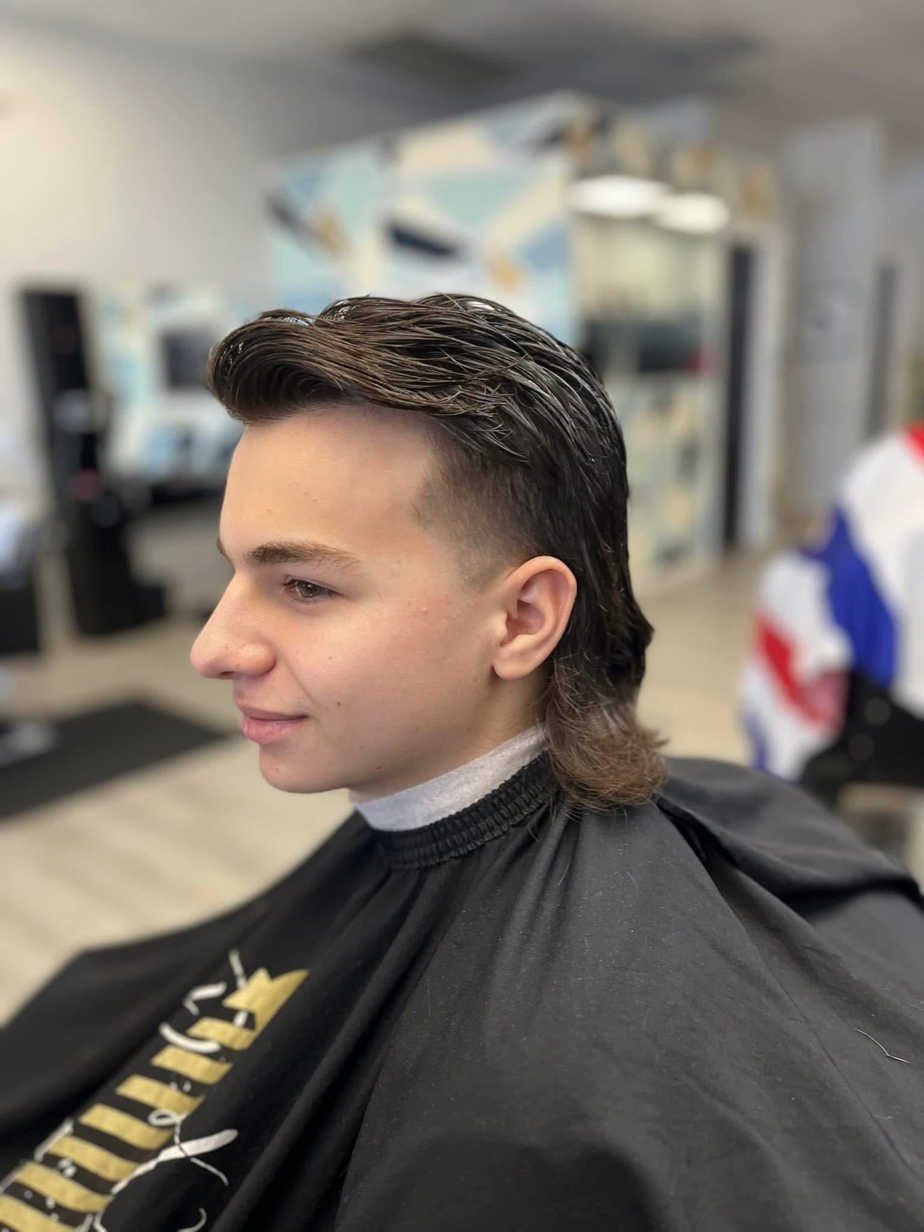Mullet with faded sides and a swept-back top, side view, by Danny at D&H Hair Company