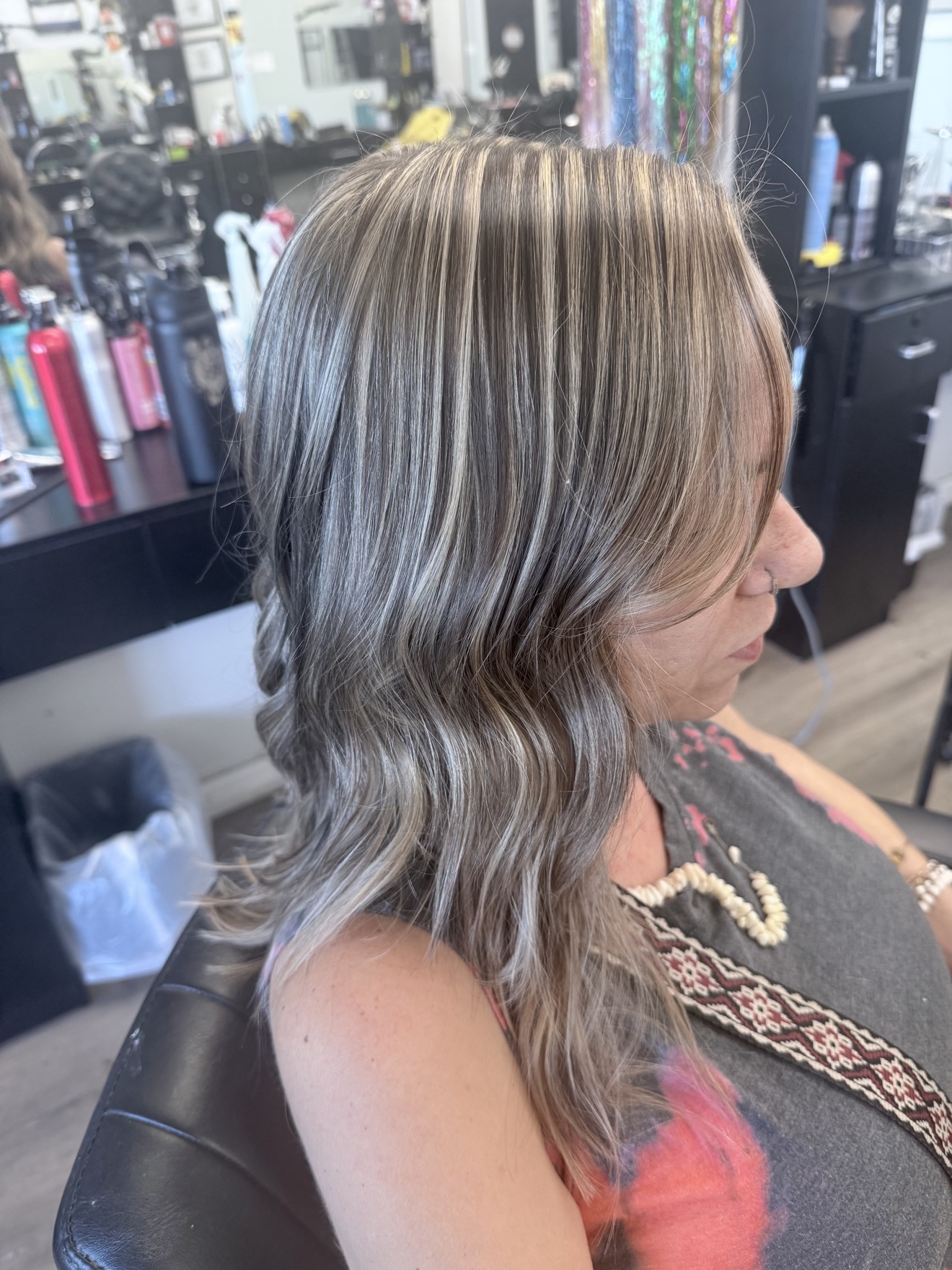 Wavy ash blonde hair with bright dimensional highlights, side view, by Heather at D&H Hair Company