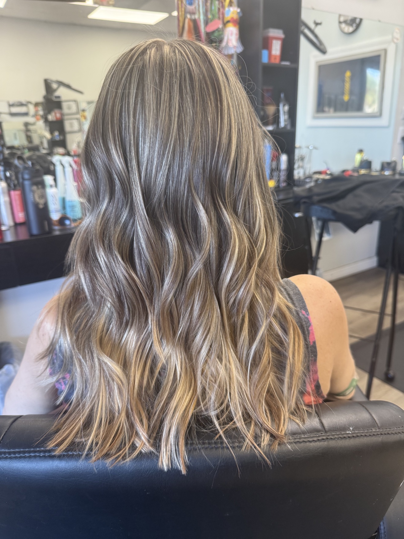 Long wavy ash blonde hair with dimensional highlights, back view, by Heather at D&H Hair Company