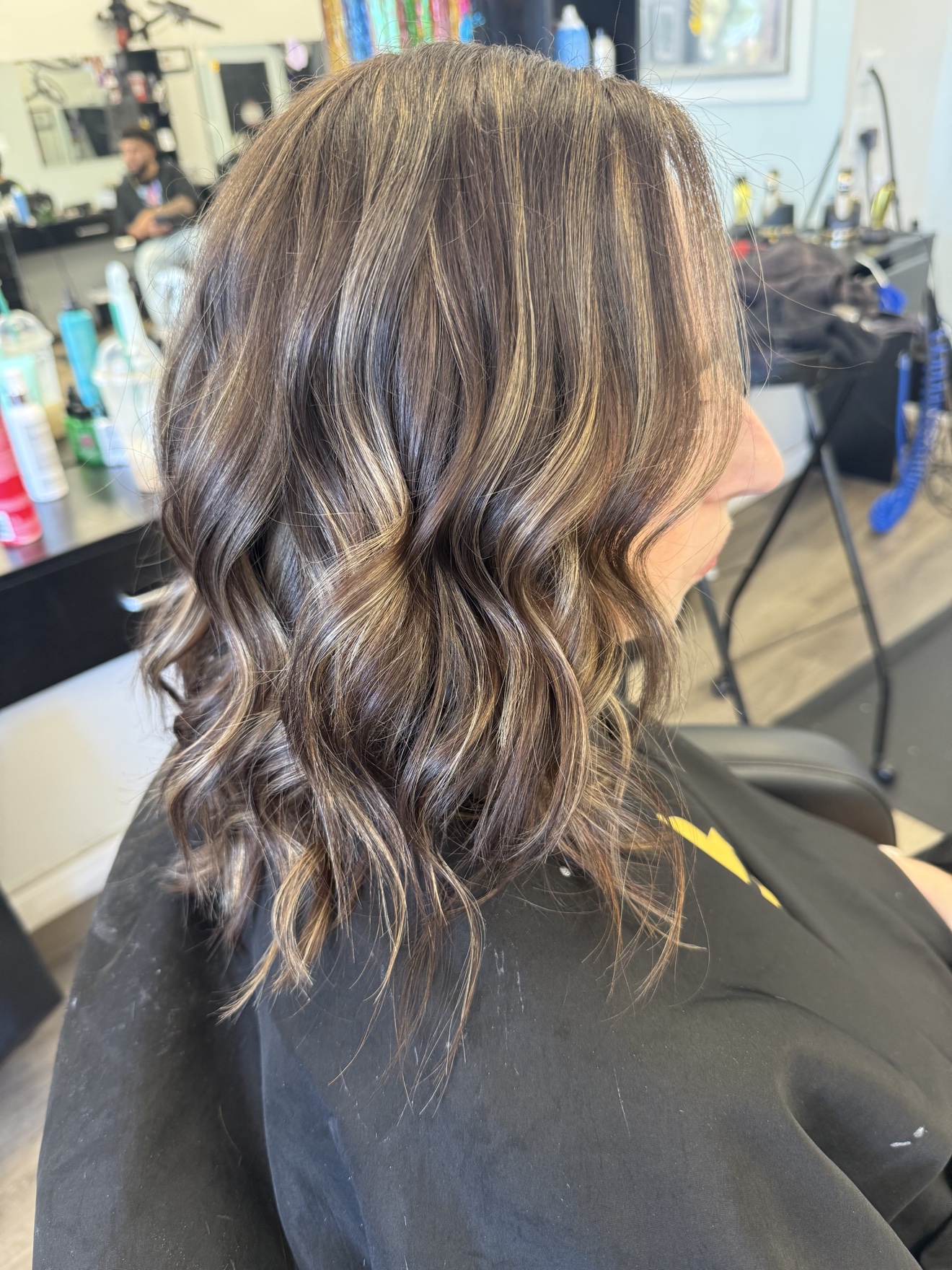 Wavy brunette hair with caramel balayage highlights, back view, by Heather at D&H Hair Company