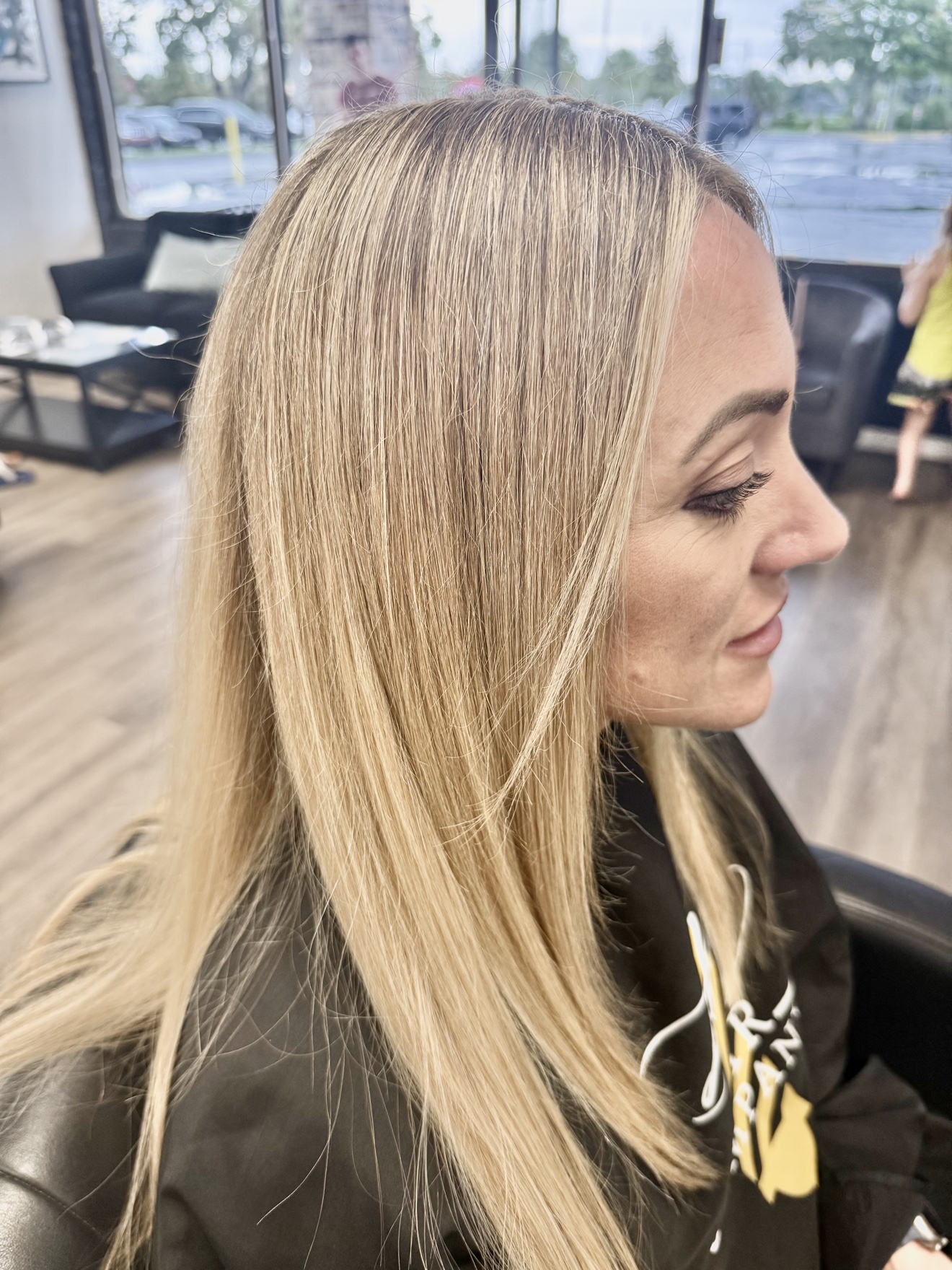 Long straight blonde hair with a smooth finish, side view, by Heather at D&H Hair Company