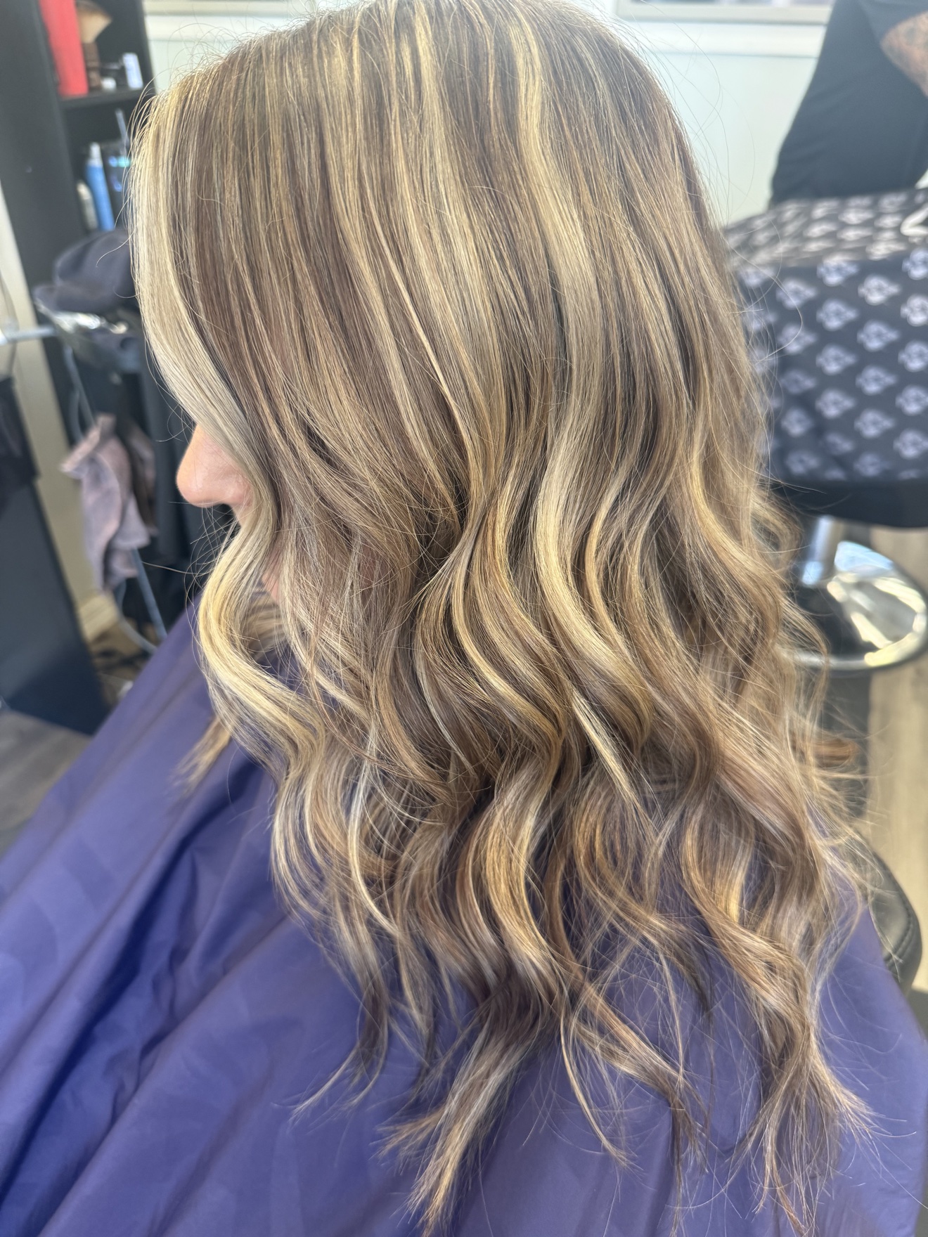 Wavy blonde hair with dimensional highlights, side view, by Heather at D&H Hair Company