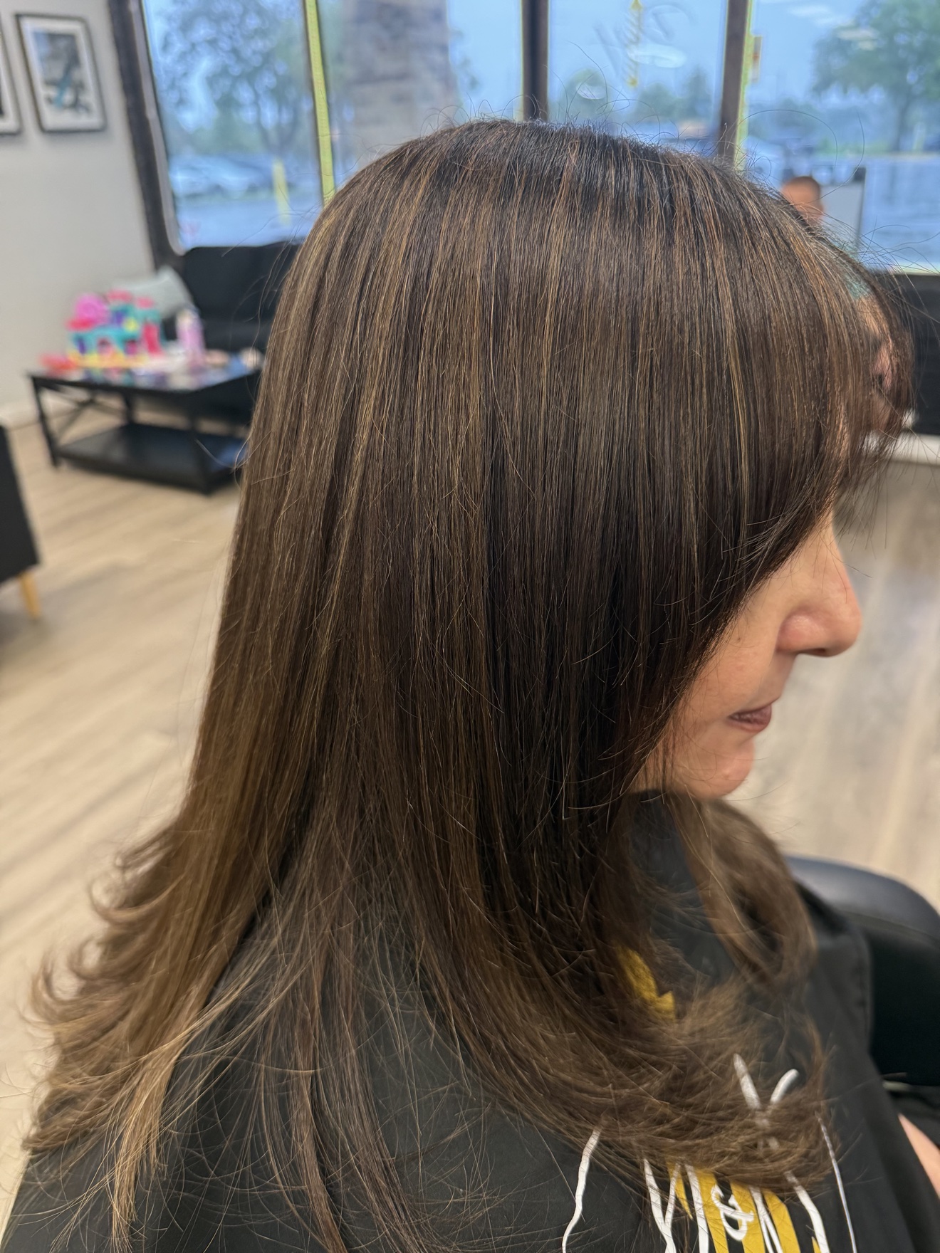 Long brunette hair with subtle highlights, side view, by Heather at D&H Hair Company