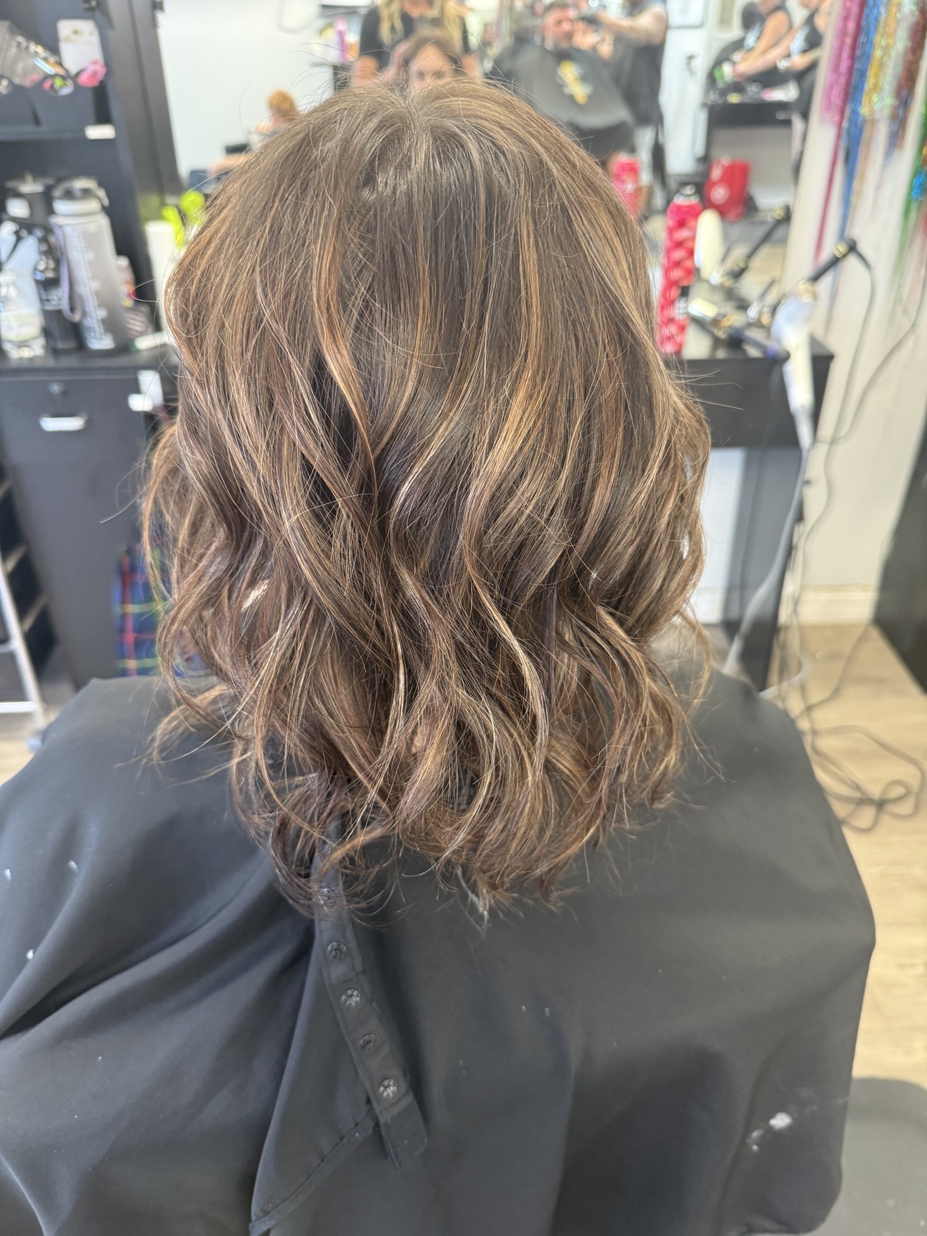 Wavy brunette hair with caramel highlights, back view, by Heather at D&H Hair Company