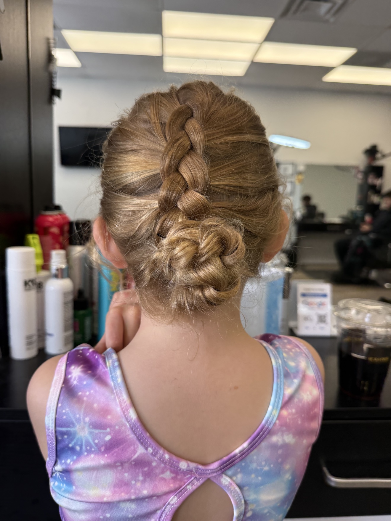 Braided updo bun on a young client, back view, by Heather at D&H Hair Company