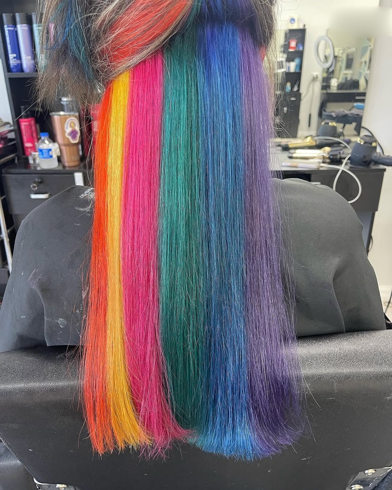 Long rainbow hair in vivid stripes of color, back view, by Heather at D&H Hair Company