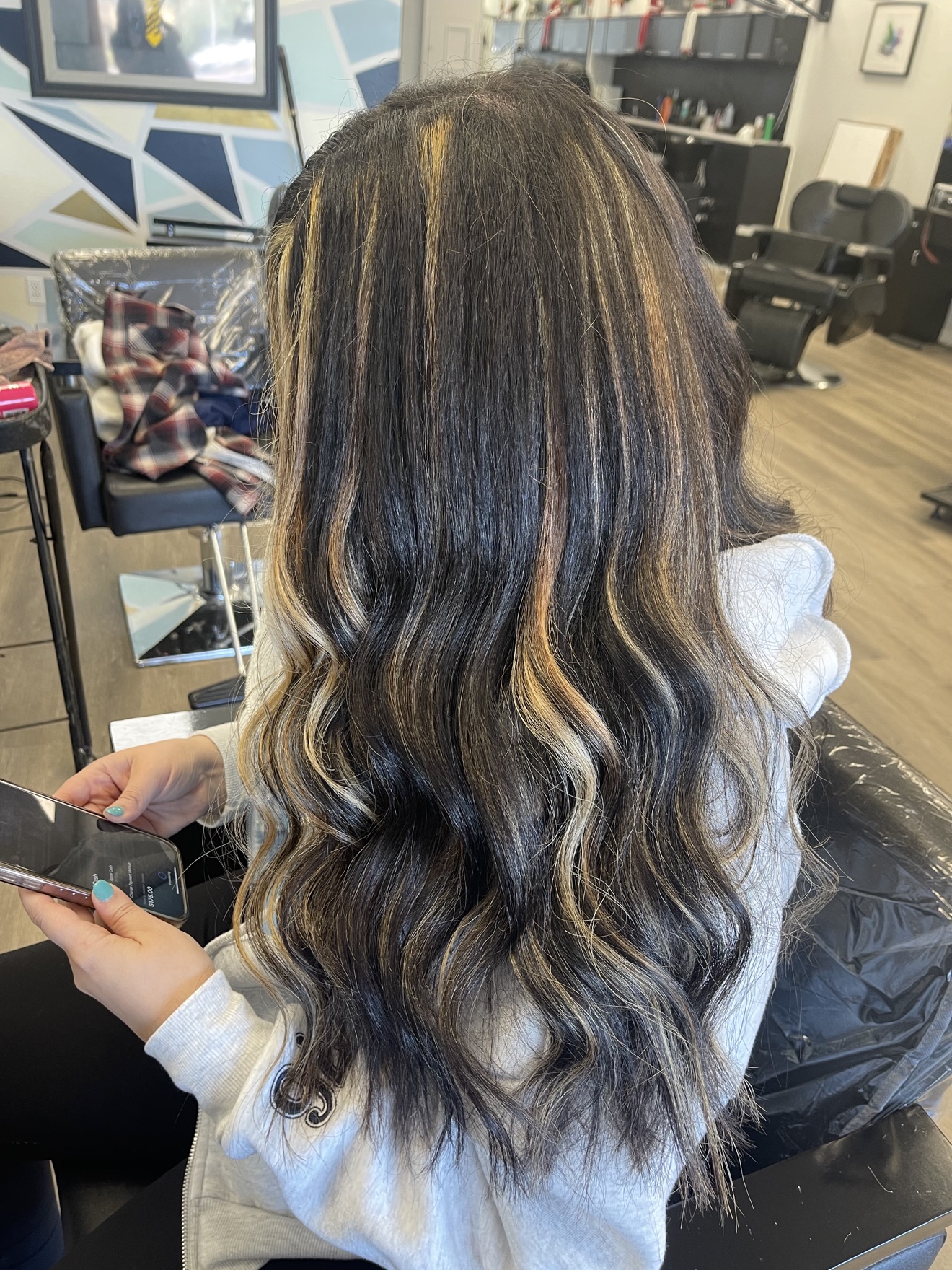 Long dark brown wavy hair extensions with blonde highlights, back view, by Heather at D&H Hair Company