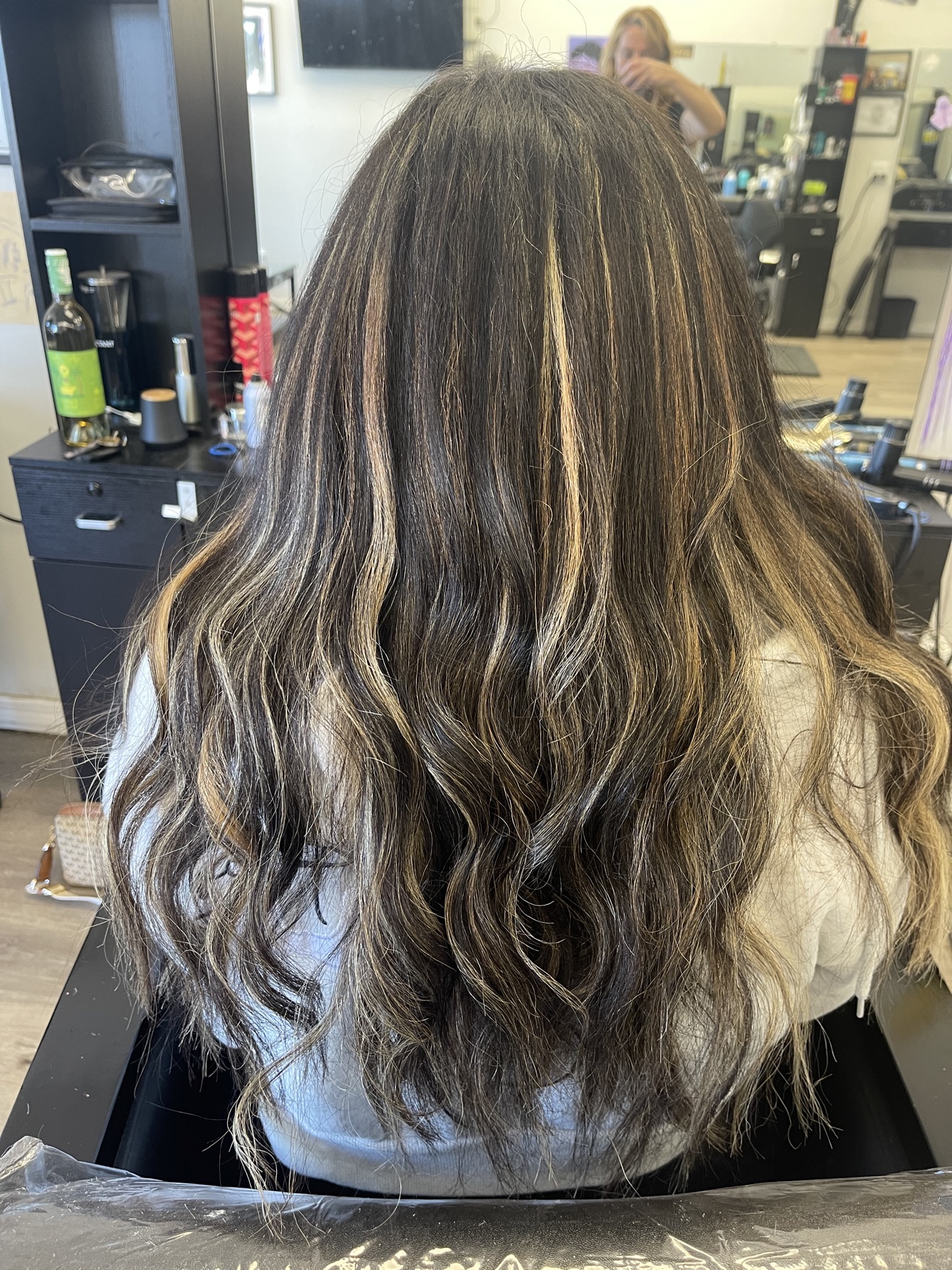 Long dark brown wavy hair extensions with blonde highlights, back view, by Heather at D&H Hair Company