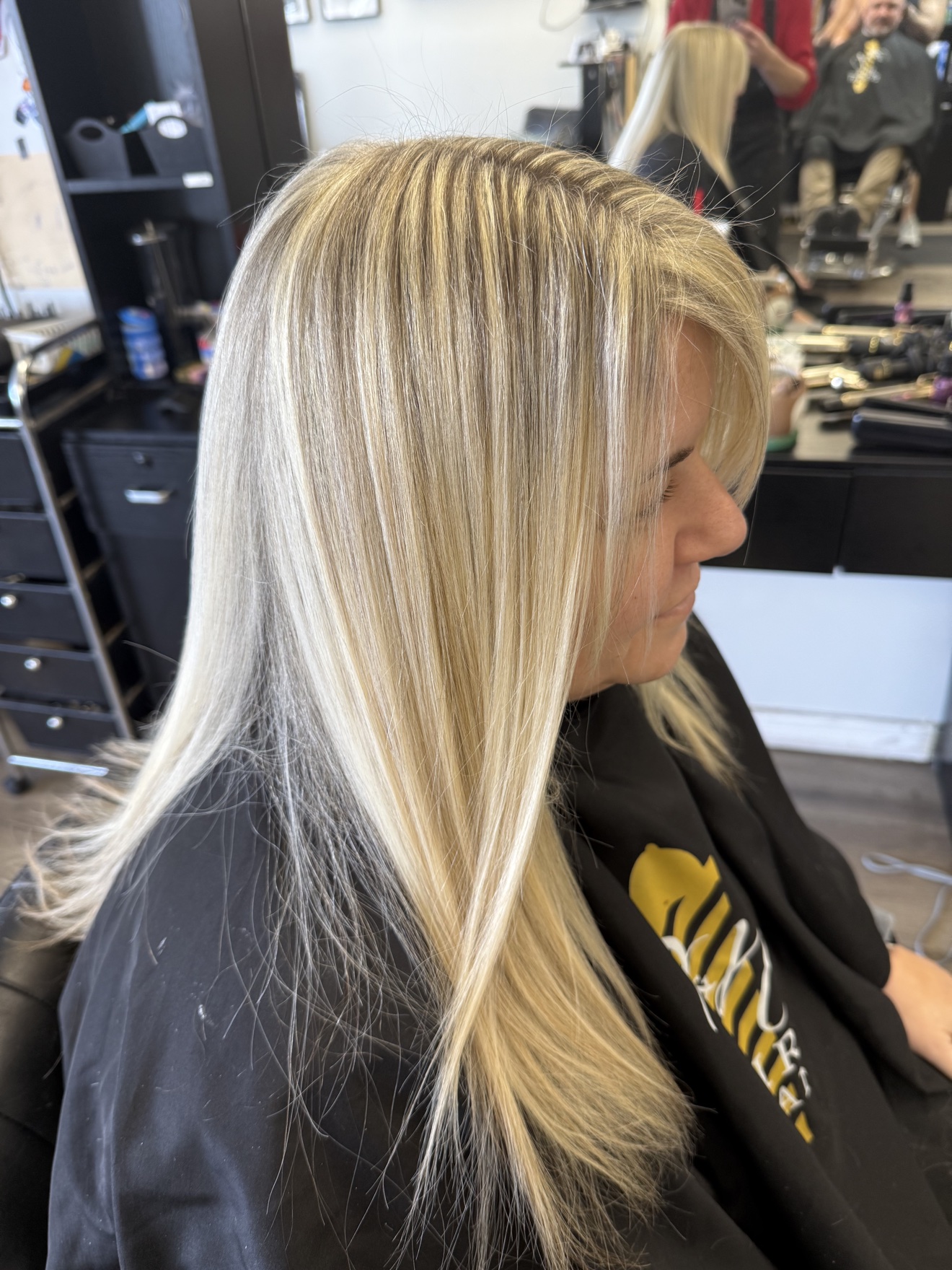 Long straight platinum blonde hair with dimensional highlights, side view, by Heather at D&H Hair Company