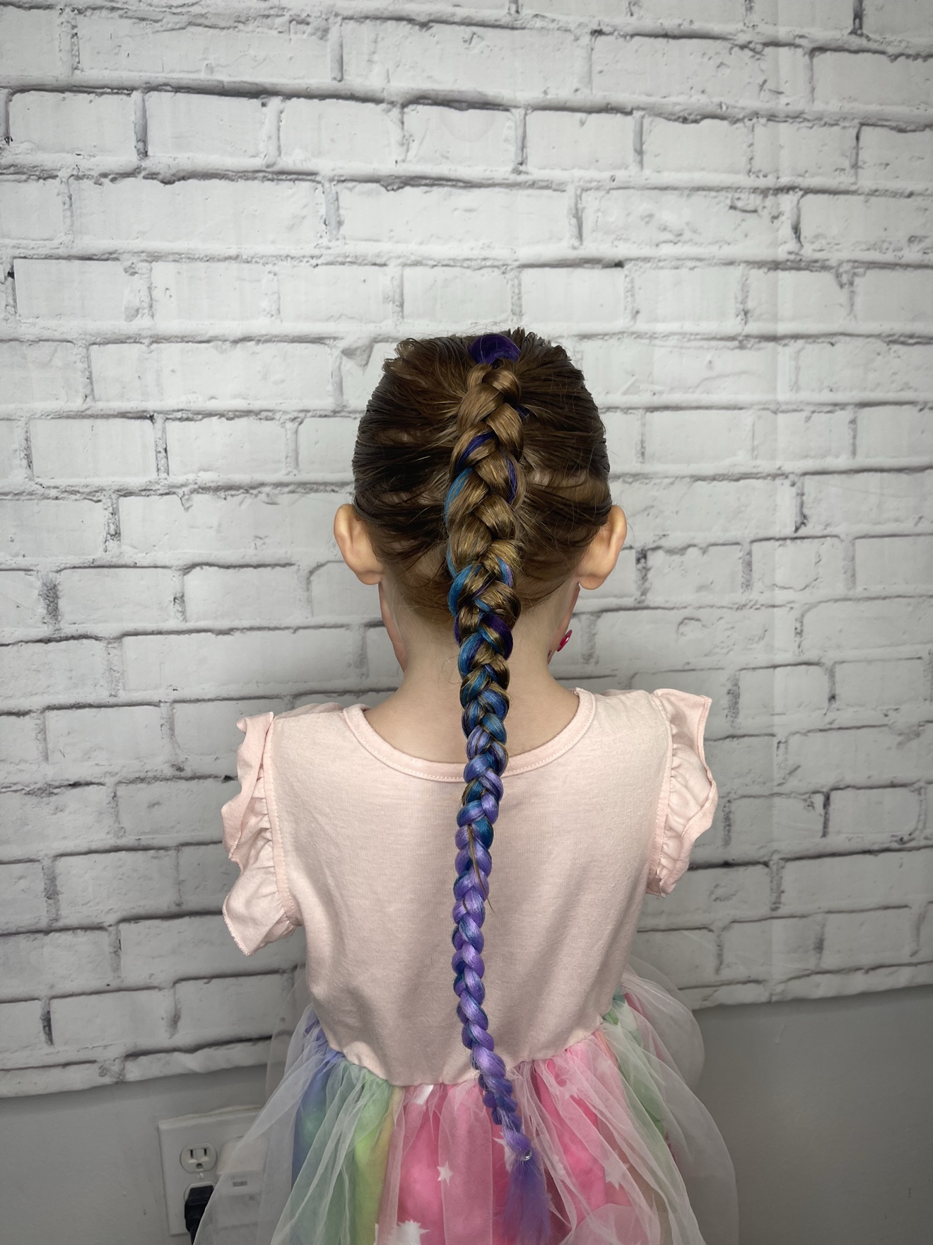 Single braid with blue and purple color on a young client, back view, by Heather at D&H Hair Company
