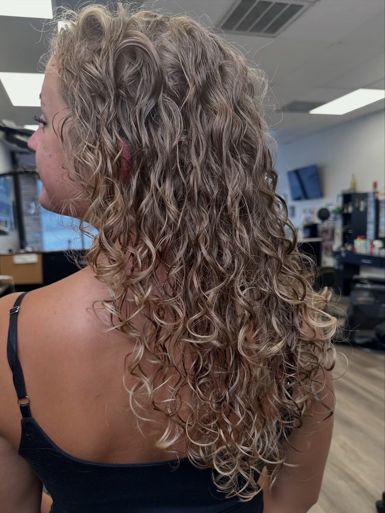 Curly ash blonde hair, side view, by Lauren at D&H Hair Company