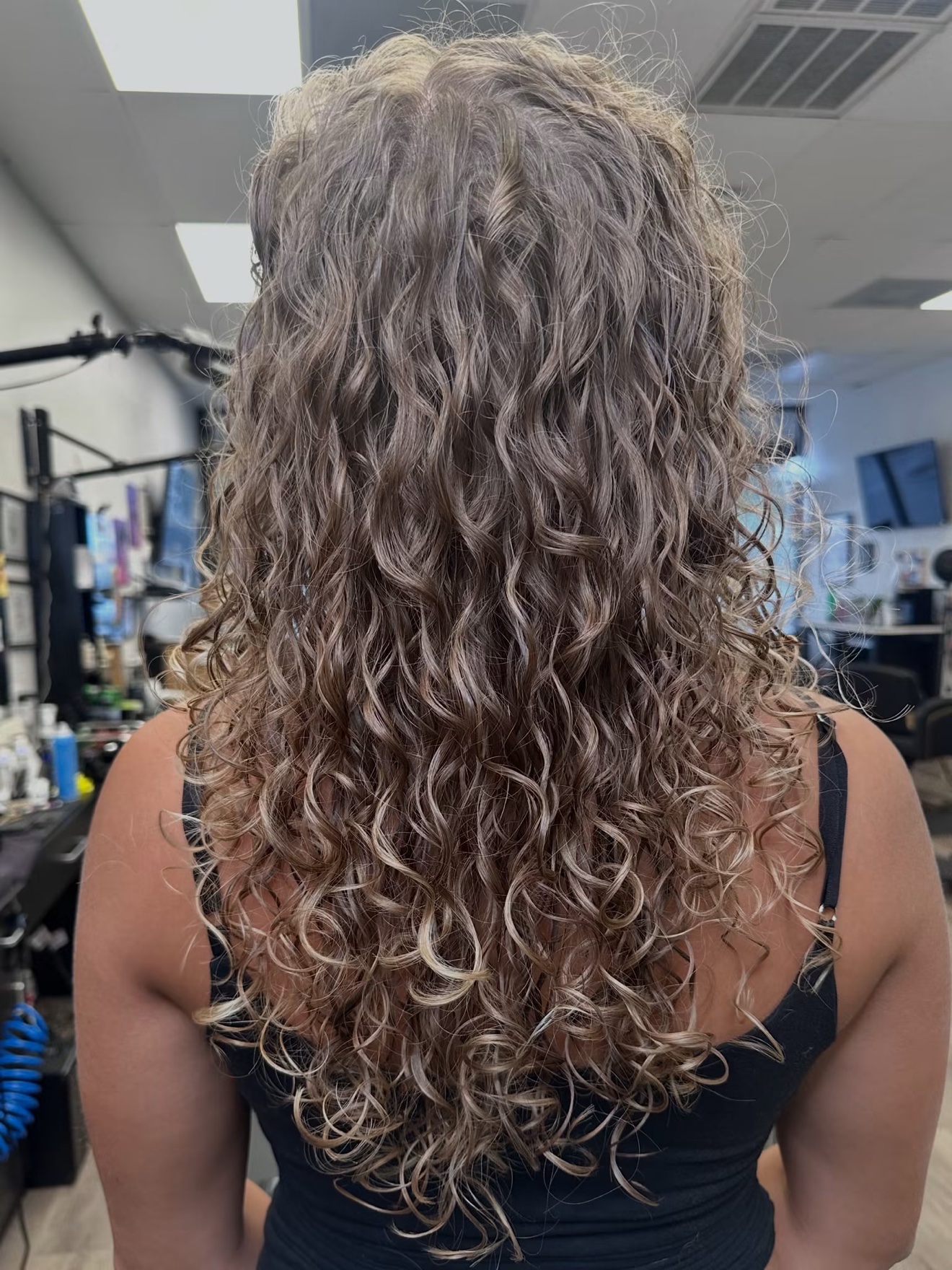 Curly ash blonde hair, back view, by Lauren at D&H Hair Company