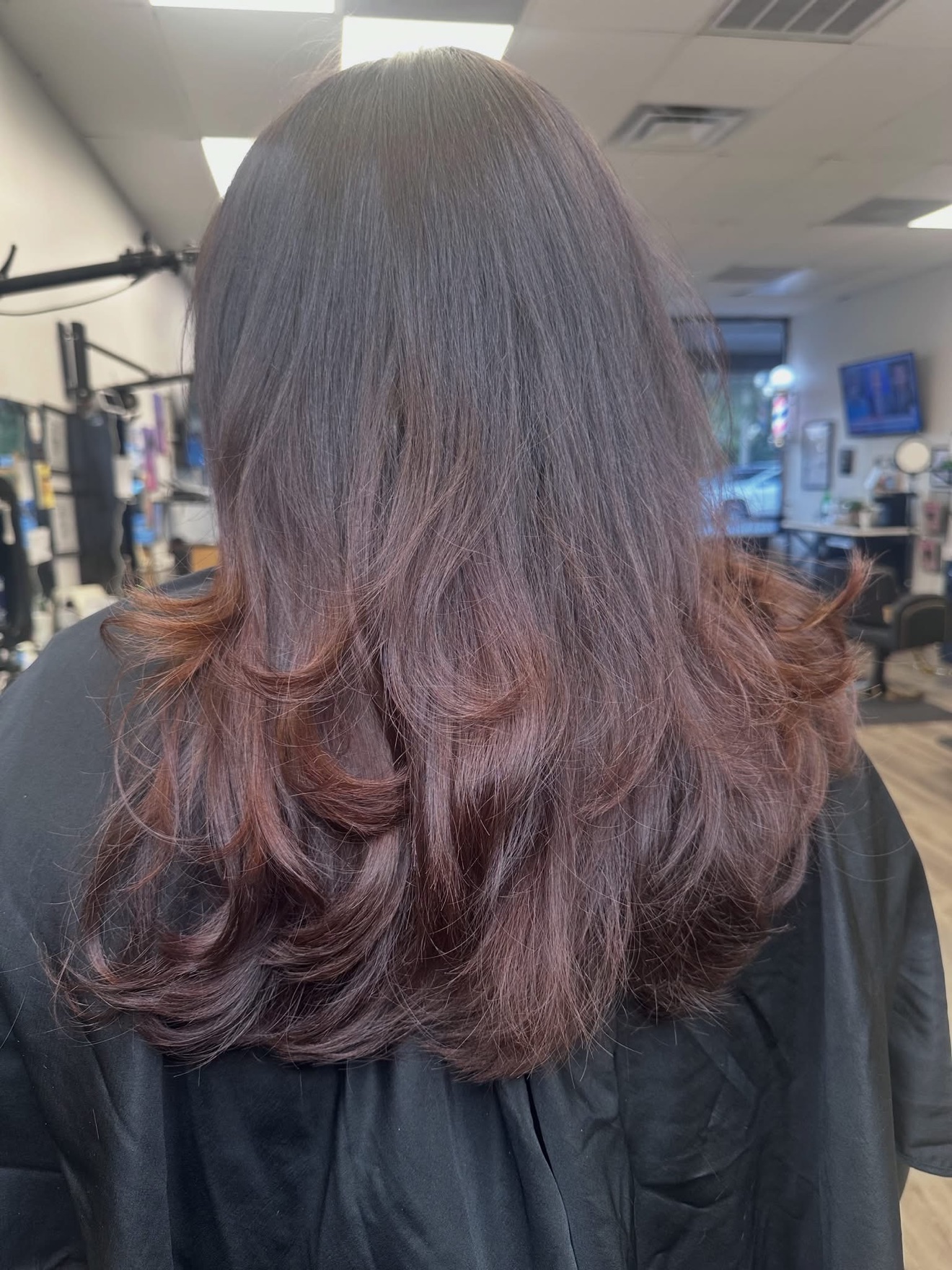 Dark brunette layered cut with warm ends, back view, by Lauren at D&H Hair Company