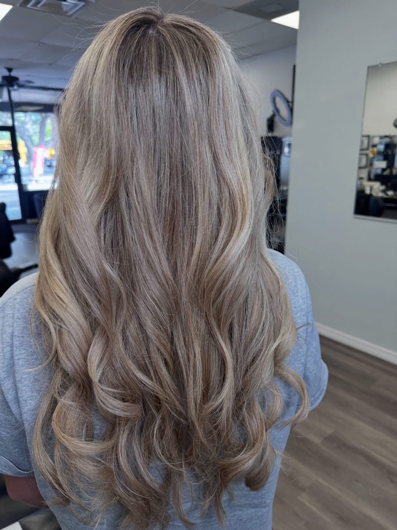 Sandy blonde wavy cut, back view, by Lauren at D&H Hair Company