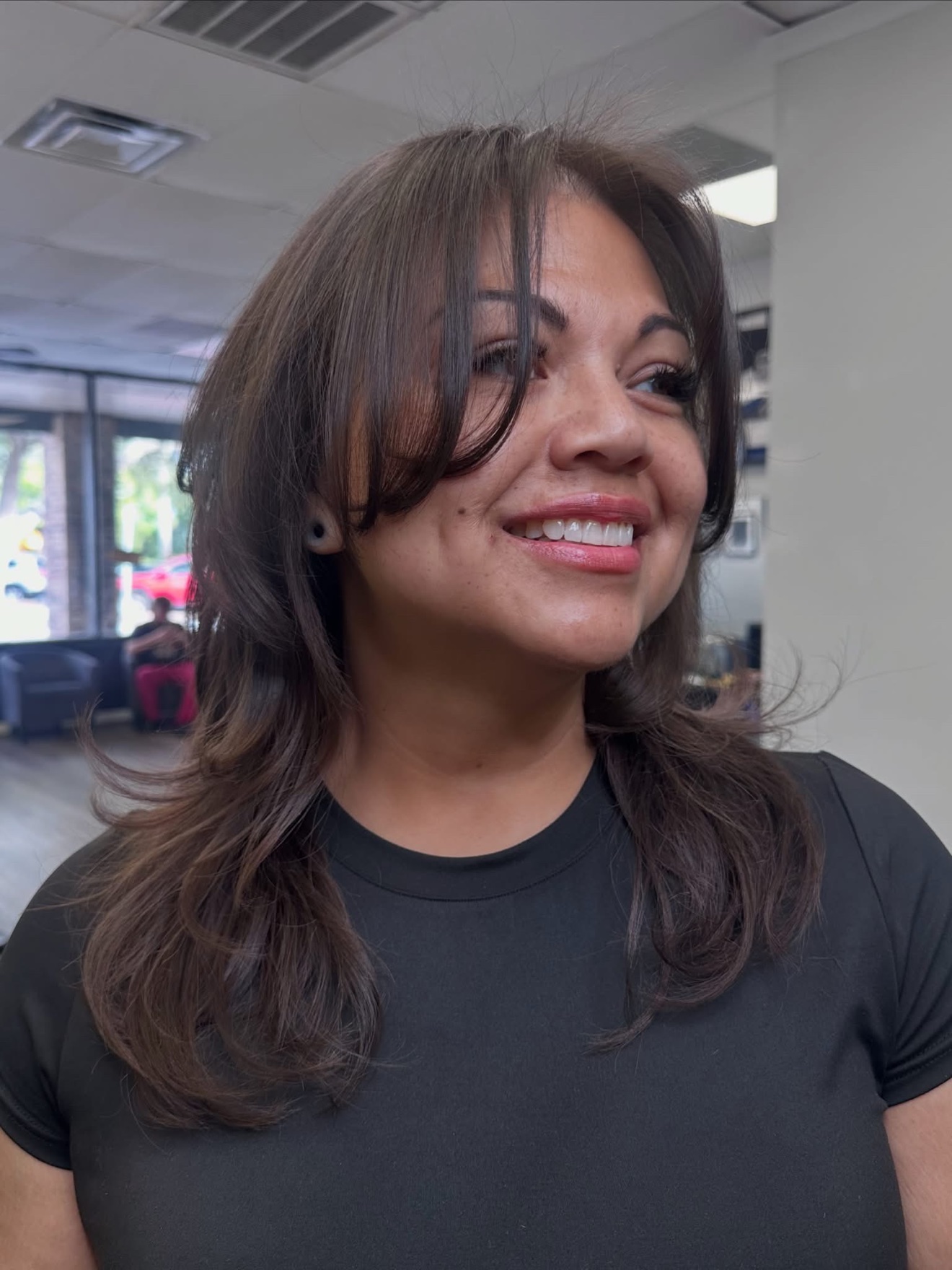 Brunette layered cut with curtain bangs, front view, by Lauren at D&H Hair Company